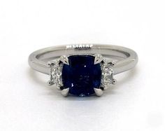 a blue sapphire and diamond ring on a white background