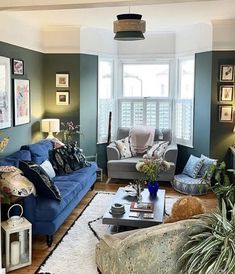 a living room filled with lots of furniture next to a large window and potted plant