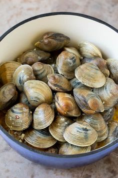 a bowl filled with clams sitting on top of a table