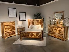 a bed room with a neatly made bed and dressers