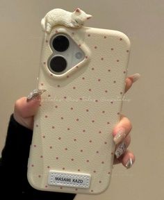 a woman holding up her phone case with a cat on it