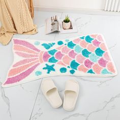 a pair of slippers sitting on top of a bathroom rug next to a bath mat