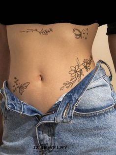 a woman's stomach with butterflies and flowers tattooed on the side, showing her lower body