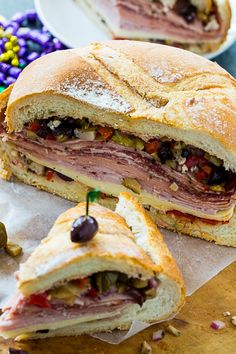 a cut in half sandwich sitting on top of a cutting board next to other food items