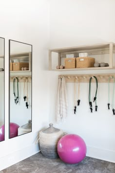 there are two exercise balls in front of the mirror and some gym equipment on the wall