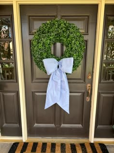 the front door is decorated with a wreath and a bow on it's side