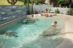 people are playing in the water at an outdoor swimming pool