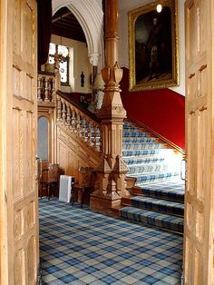 an open door leading to a blue and white checkered carpeted floor with stairs