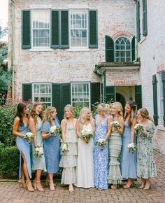 a group of women standing next to each other in front of a building