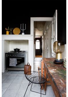 a kitchen with an oven, stove and table next to it's doorway leading into the dining room