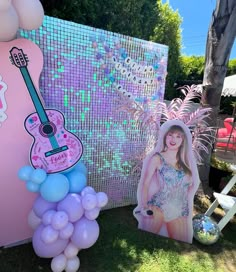 there is a pink guitar and balloons on the ground