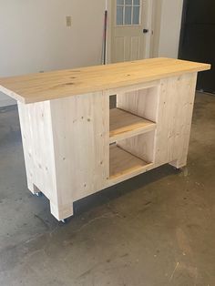 a kitchen island made out of plywood with shelves on each side and an open door