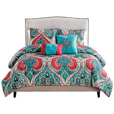 a bed with colorful pillows on top of it and a headboard in the background