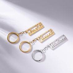 three metal keychains with names on them