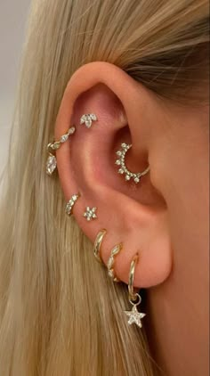 a woman's ear with three different types of piercings