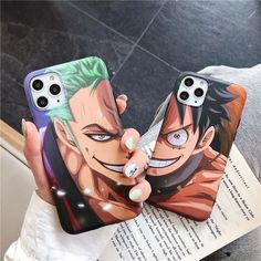 two cell phones with anime characters painted on them, one is holding the phone case