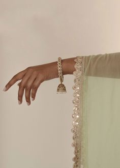 Adorn your wrists with the refined elegance of our antique gold Saavana Bangles, featuring almond-shaped gems and cream stones. The dangling jhumkas add a touch of sophistication, perfect for standalone chic or curated bangle ensembles. Includes 2 bangles. Elegant Gold Sharara With Meenakari, Elegant Meenakari Sharara For Eid, Elegant Meenakari Sharara For Diwali, Festive Elegant Sharara With Meenakari, Elegant Festive Meenakari Sharara, Elegant Festive Sharara With Meenakari, Elegant Festive Sharara With Meenakari Details, Traditional Sharara With Intricate Design For Festive Occasions, Gold Tilla Sharara For Eid