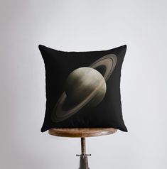 a black pillow with saturn on it