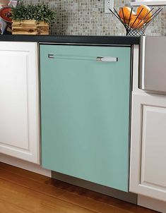 a blue dishwasher sitting on top of a wooden floor next to white cabinets