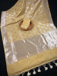 Gorgeous Beige Gold Saree with Muted Sliver Zari Weave Work. Traditional Banarasi Silk Handloom Banarasi Saree. Item : SareeColor : Beige Gold ColorBase Fabric : Handloom Banarasi SareeBlouse piece : Comes with Blouse pieceFall & Edging (Yes/No) : Yes Disclaimer -:- Color variation is possible due to various reasons like phone or desktop setting, resolution etc. Please don't hold us responsible. Our aim is to put the exact color of the Saree.- If the Saree is Pure Silk, we will put it very clear Festive Silver Chanderi Blouse Piece, Silver Chanderi Traditional Wear For Eid, Silver Bollywood Style Art Silk Dupatta, Silver Bollywood Art Silk Dupatta, Bollywood Style Silver Art Silk Dupatta, Silver Traditional Wear With Dupatta For Navratri, Silver Zari Work Tissue Silk Dupatta, Silver Tissue Silk Dupatta With Zari Work, Silver Saree With Dupatta For Navratri