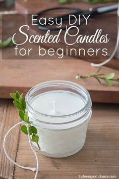 a glass jar filled with white candles on top of a wooden cutting board next to scissors and