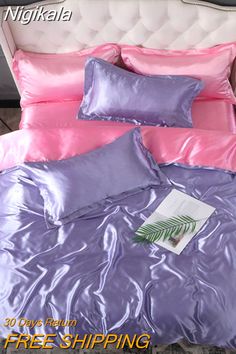 a bed with pink and purple sheets on it