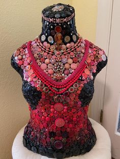 there is a very large piece of clothing made out of buttons and other things on the mannequin