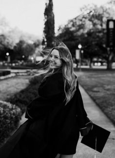 black and white photo of woman walking down sidewalk