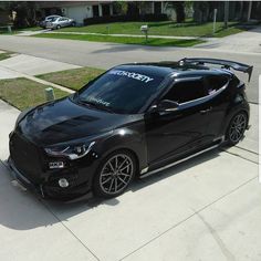 a black car parked on the side of a street