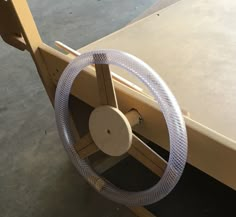 a steering wheel attached to the side of a wooden boat with metal spokes on it