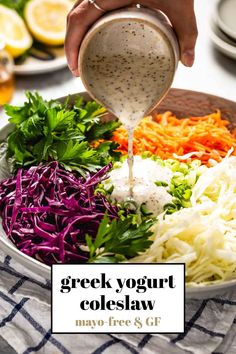 a person pouring dressing into a bowl filled with coleslaw, carrots and parsley