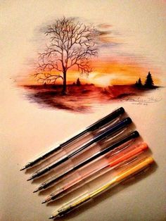 some watercolor pencils are laying on top of a piece of paper with a tree painted on it