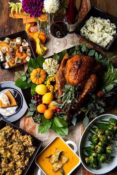 an assortment of thanksgiving foods on a table with flowers and other food items around it