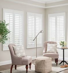 a living room with two chairs and a footstool in front of the window