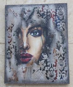 a painting of a woman's face with blue eyes and red lips on a tile wall