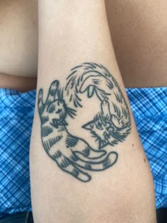 a woman's arm with a cat tattoo on it