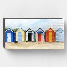 a painting of colorful beach huts in the sand