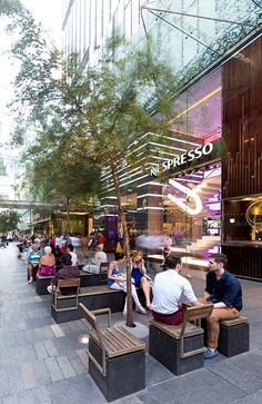 people are sitting on benches in front of a building with the words represso written on it