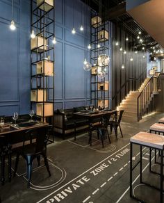 an instagramted photo of a restaurant with blue walls and wooden tables in the center