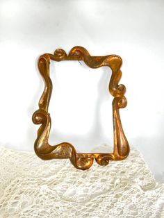 a gold frame sitting on top of a white doily