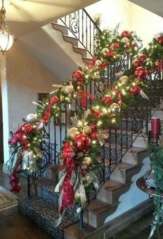 a staircase decorated for christmas with red and green decorations on the bannister railing