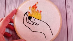 a hand embroideryed picture of a person holding a fireball