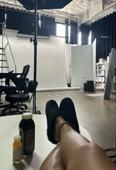 a person laying on the table with their feet up in front of an empty room