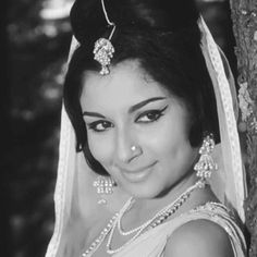 a woman in a wedding dress posing for the camera with her veil draped over her head