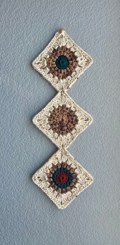 three crocheted squares hanging on the wall