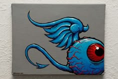 a painting of a blue fish with red eyes on it's head and tail