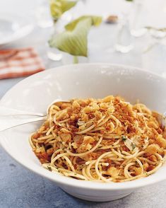 a white bowl filled with pasta on top of a table