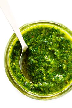 a spoon in a jar filled with pesto