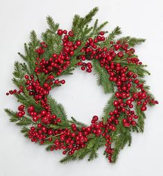 a christmas wreath with red berries and green leaves