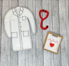 a doctor's coat and stethoscope next to a small cardigan